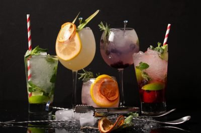 A diverse collection of colorful cocktails with garnishes, perfect for a refreshing drink experience.